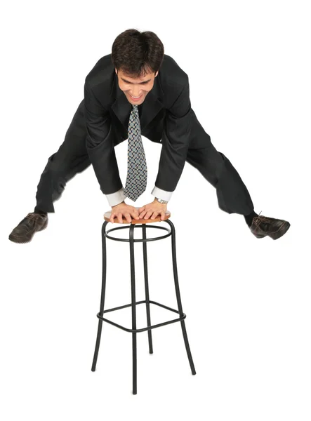 Бизнесмен прыгает выше табуретки — стоковое фото
