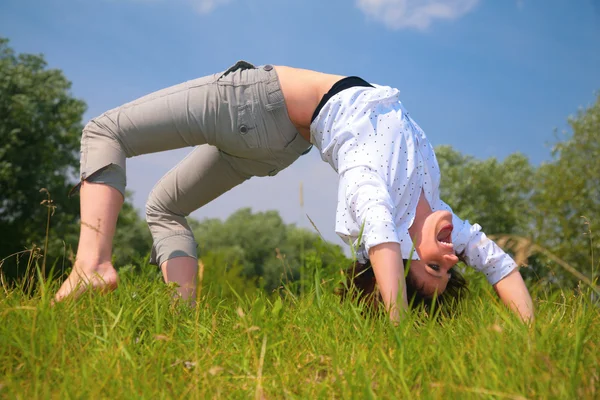 Woman does exercise on grass — Stock Photo, Image