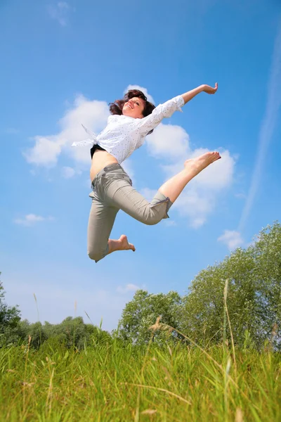 Skönhet kvinna hoppar på gräs — Stockfoto