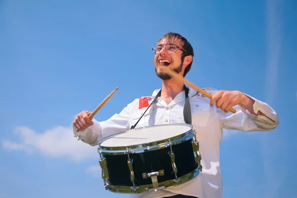 Молодий чоловік в окулярах грає на барабані — стокове фото