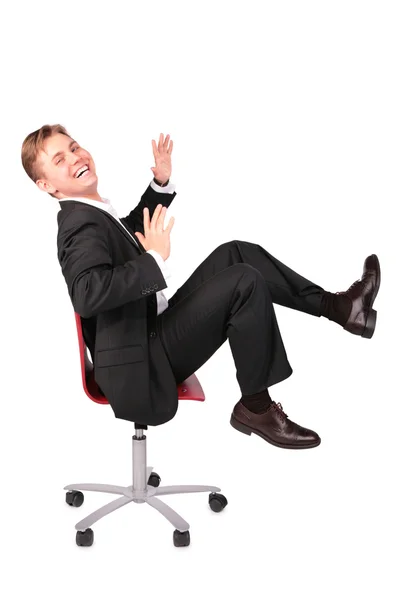 Mladý muž v obleku smích sedí na židli — Stock fotografie