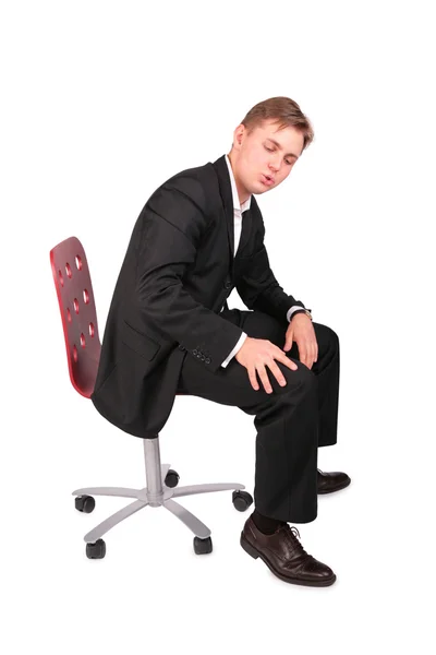 Takım elbiseli genç adam koltuğa oturur — Stok fotoğraf