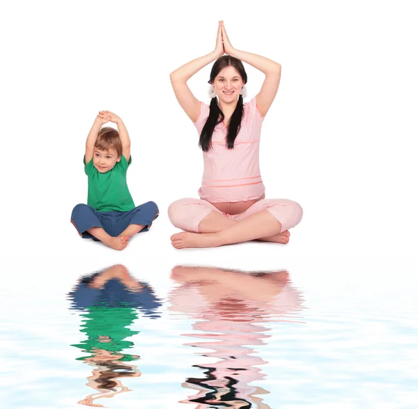 Pregnant girl with child doing exercise siting — Stock Photo, Image