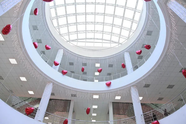 Interior of commercial center, decorated with infatable hearts — Stock Photo, Image