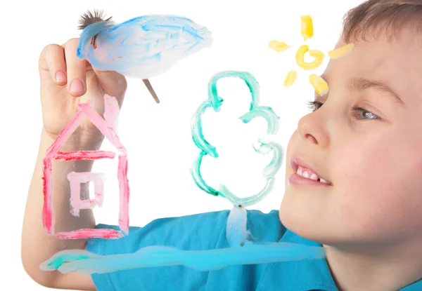 Boy paints on glass cloud and house — Stock Photo, Image