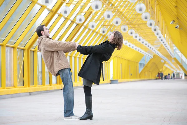 Chico y chica abrazarse unos a otros para manos en pasarela — Foto de Stock