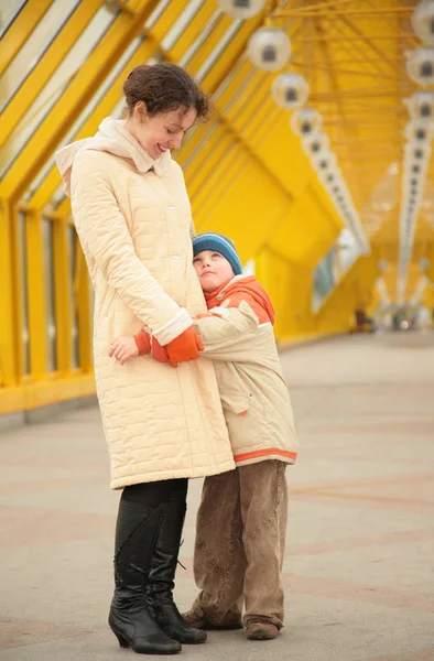 Сын обнимает мать на пешеходном мосту — стоковое фото