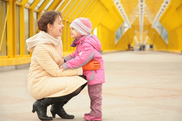 Mother and daughter look each other on footbridge — Stock Photo, Image