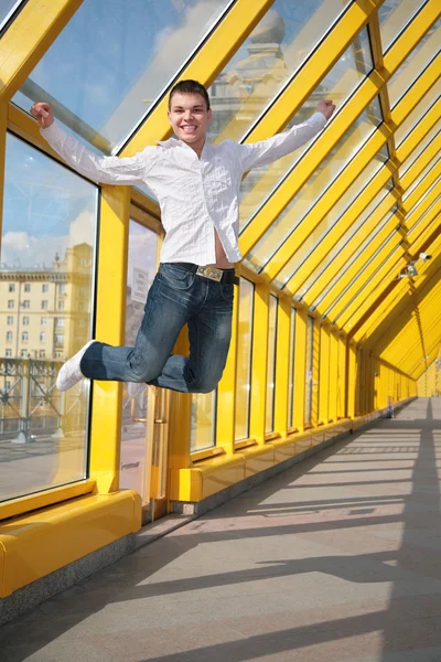 Молодой человек прыгает по пешеходному мосту — стоковое фото