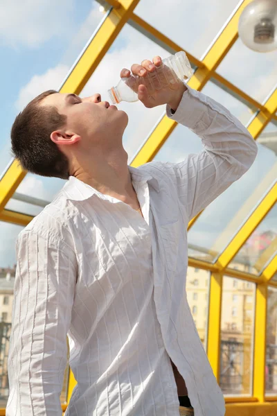 Jongen drinkt uit fles on Footbridge based — Stockfoto