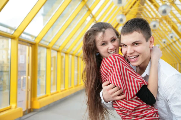 Ragazzo abbraccia ragazza sul ponte pedonale — Foto Stock