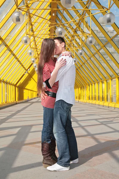 Young pair kisses on footbridge — Stock Photo, Image
