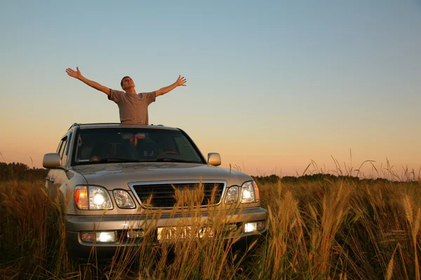 Man with offroad car in field — Stock Photo, Image