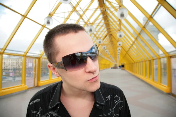Guy in sunglasses on yellow footbridge — Stock Photo, Image