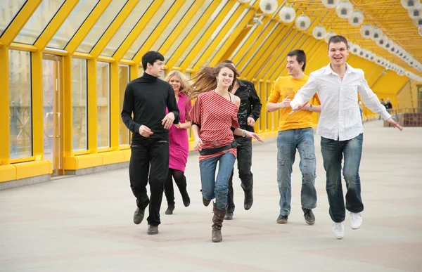 Group of friends runs on footbridge — Stock Photo, Image