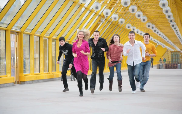 Groep vrienden draait op gele footbridge — Stockfoto