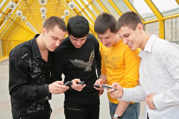 Skupina mladých mužů s mobilní telefony — Stock fotografie