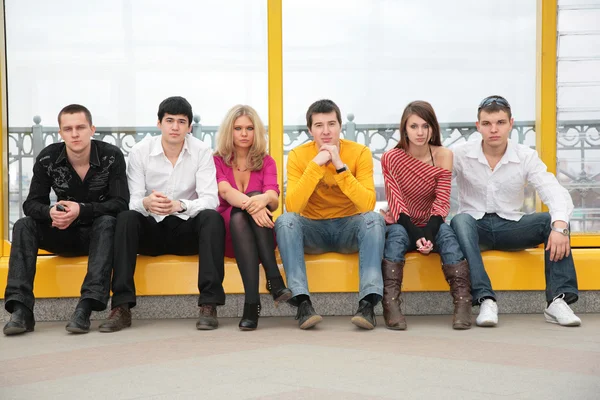 Sześciu młodych osób usiąść na kładce — Zdjęcie stockowe