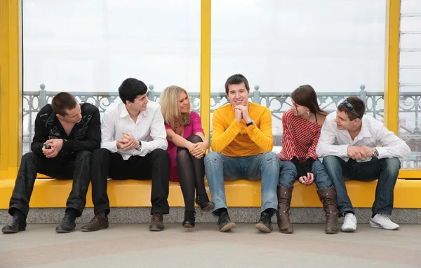 Grupa młodych siedzieć na kładce — Zdjęcie stockowe