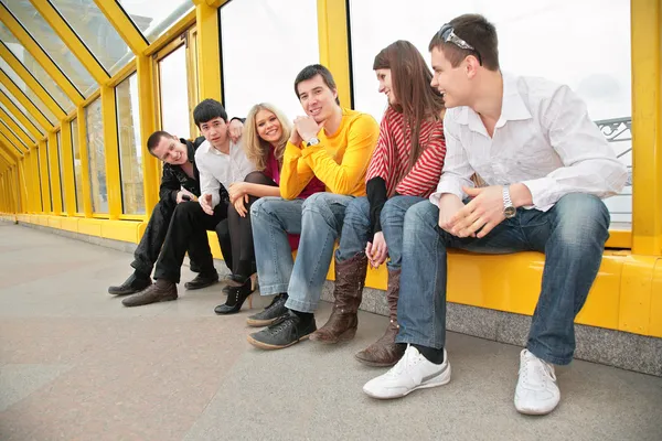Group of young persons sit on footbridge — Stock Photo, Image