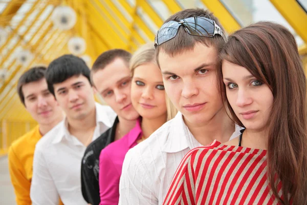 Group of serious young persons stand on footbridge — Stock Photo, Image