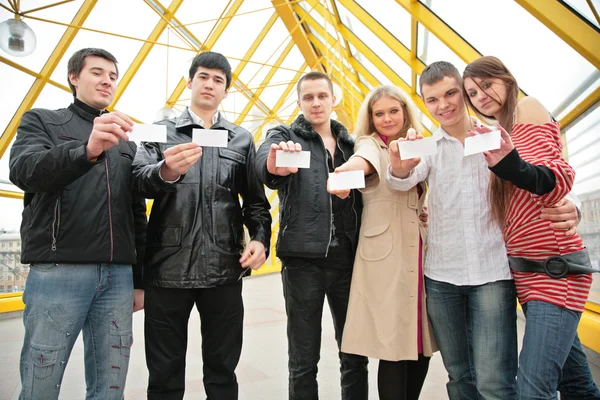Group of young hold blank cards in hands on footbridge — Stock Photo, Image