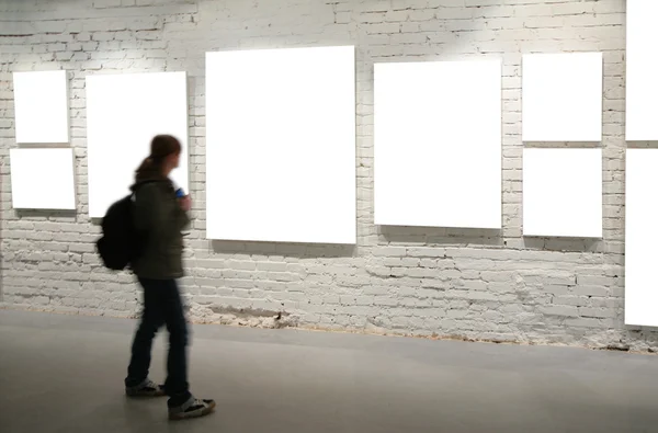 Girl walk through frames on a brick wall — Stock Photo, Image