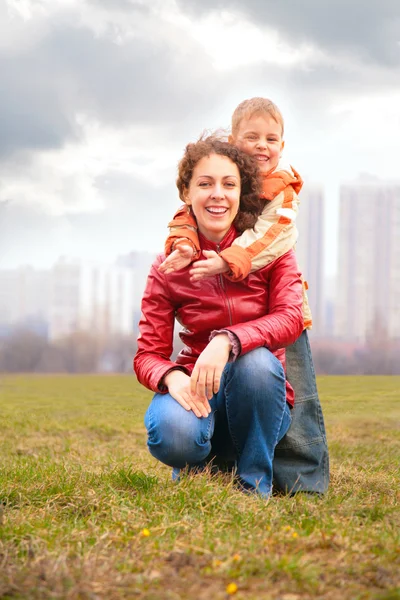 Son embraces mother from back — Stock Photo, Image
