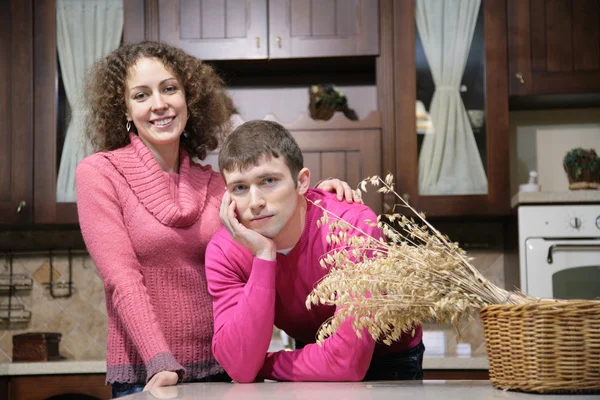 Jovem casal na cozinha e cesta com ervas secas — Fotografia de Stock