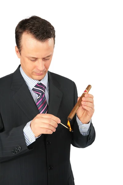 Businessman lights a cigar — Stock Photo, Image