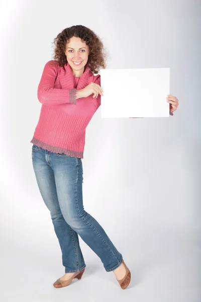 Jovem mulher se levanta e manter folha branca de papel — Fotografia de Stock
