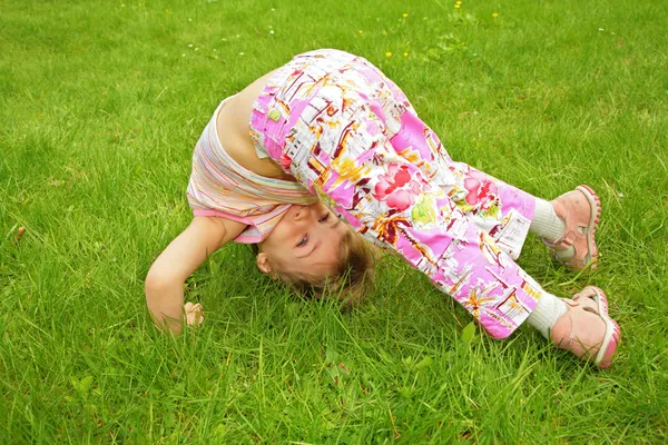 Μικρό κορίτσι κάνει άσκηση στο γρασίδι — Φωτογραφία Αρχείου
