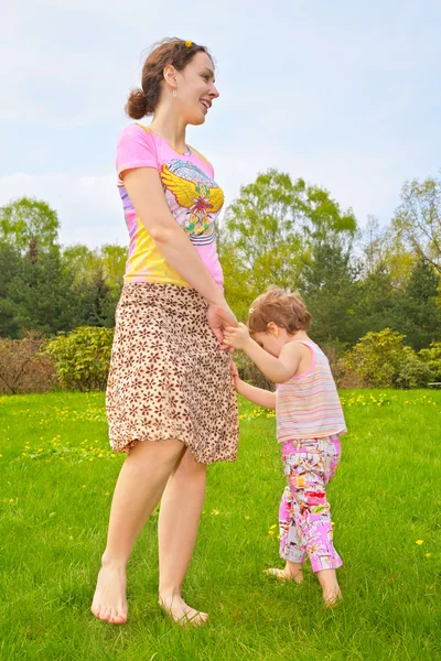 母亲与女儿在草坪上的光脚走 — 图库照片