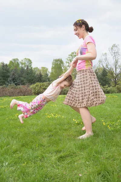 Mãe vira filha para mãos no gramado — Fotografia de Stock