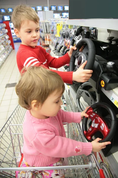 Broer en de zus in winkel draai joysticks — Stockfoto