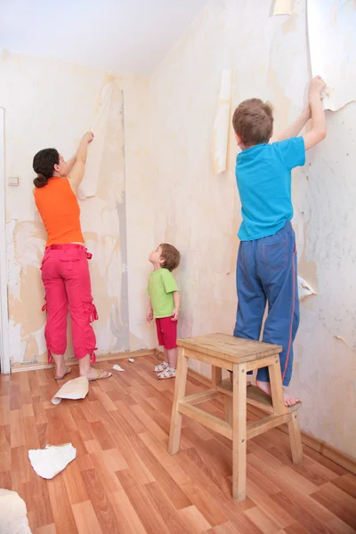 壁から壁紙を張るの子供を持つ母 — ストック写真