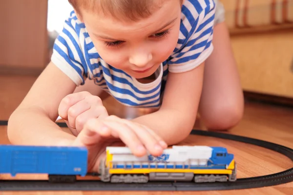 Jongen spelen met speelgoed spoorweg — Stockfoto