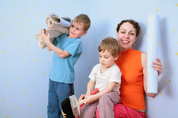 Çocuk duvar kağıdı yapıştırmak için mothrer yardım et. — Stok fotoğraf