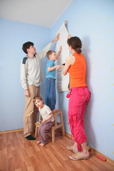 Γιος βοηθούν τους γονείς να κολλήστε ταπετσαρίες τοίχου — Φωτογραφία Αρχείου