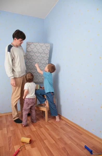 Barnen hjälpa pappa att limma väggen-papper — Stockfoto