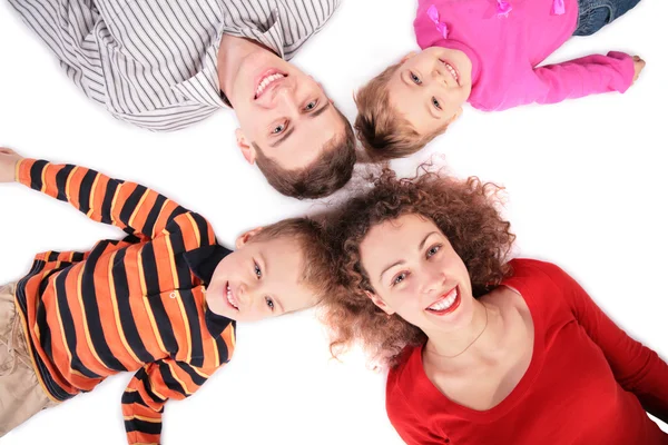 Čtyřčlenná rodina ležící na podlaze — Stock fotografie