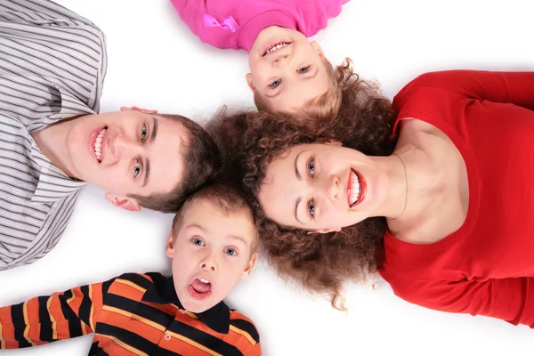 Čtyřčlenná rodina ležící na podlaze — Stock fotografie