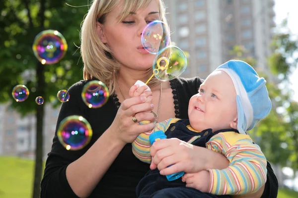 Matka s dítětem je spuštěn se mýdlové bubliny — Stock fotografie