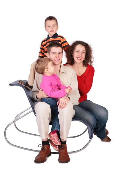 Family of four sits on chair — Stock Photo, Image