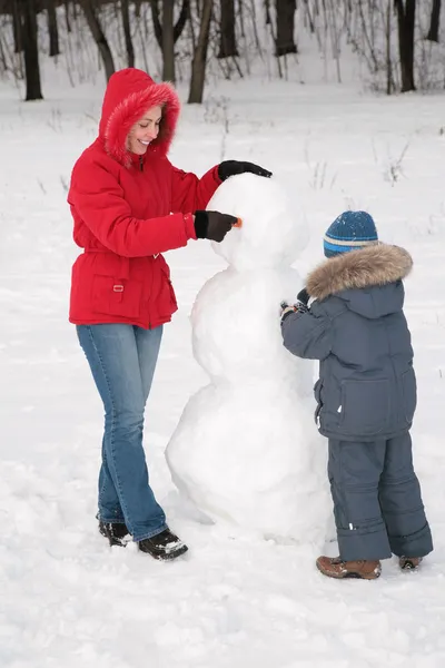 Matka a dítě, aby sněhulák — Stock fotografie