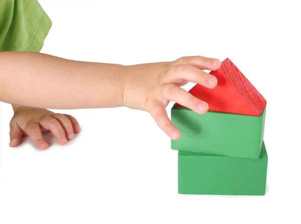 Children's hand en speelgoed huis van kubussen — Stockfoto
