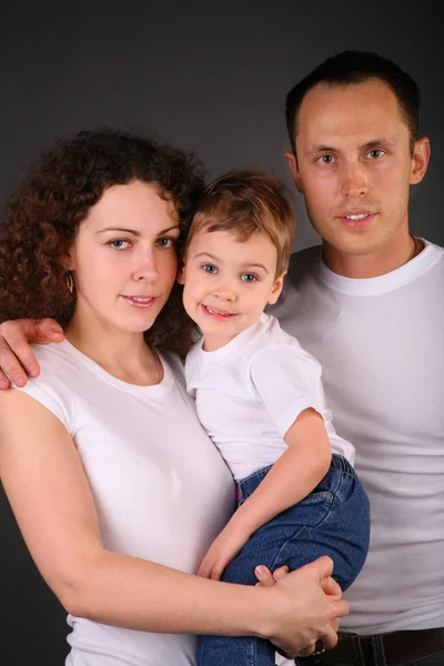 Ouders met kind op handen op donkere achtergrond — Stockfoto