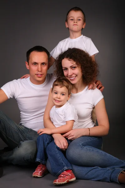 Οικογένεια στο στούντιο σε σκούρο φόντο — Φωτογραφία Αρχείου