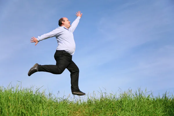 Fat man jumps on meadow — Stock Photo, Image