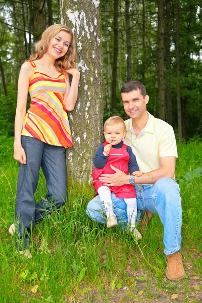 Familjen under ett träd i parken — Stockfoto